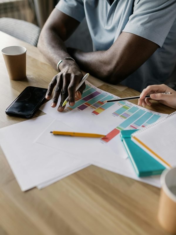 two men sitting down at a table looking over charts and data