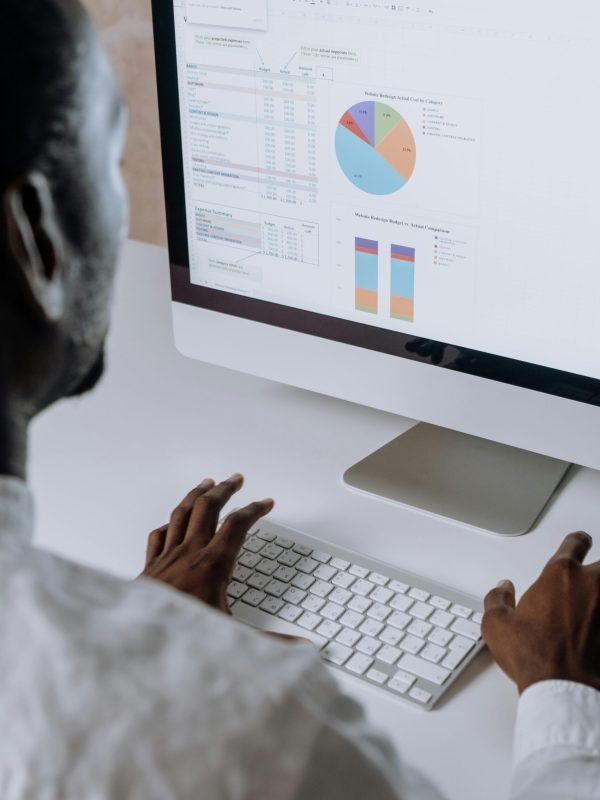 man sitting at desk looking at computer doing data analysis