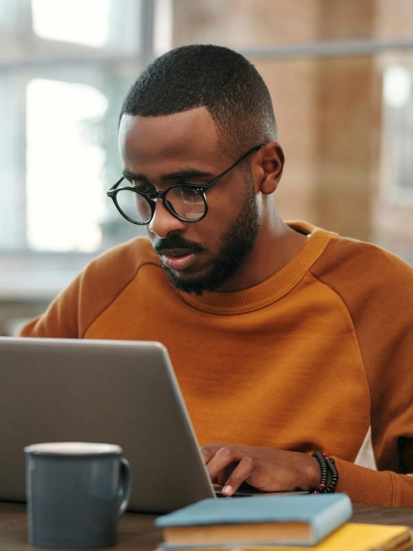 man sitting down looking at computer doing work