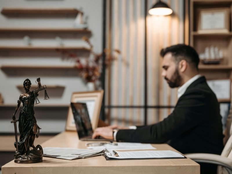 man sitting down at desk in a lawyer office on computer