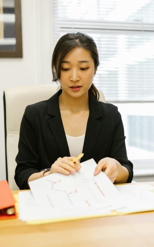 lady sitting down behind a desk looking down at paperwork